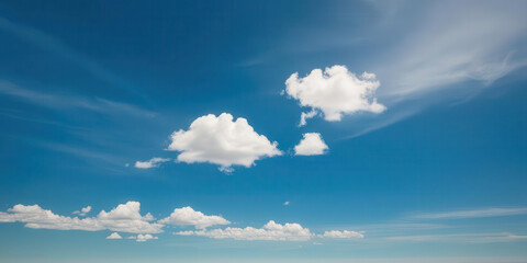 Fototapeta premium Bright blue sky with fluffy white clouds scattered across horizon