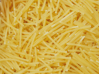Close-up of small, thin vermicelli filini pasta. Delicate strands create a fine, textured food background.