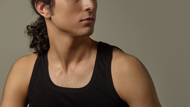 Close-up cropped image of male face, neck and jawline with strong bone structure, smooth hydrated skin against neutral background. Concept of skincare, men beauty, self-care, confidence