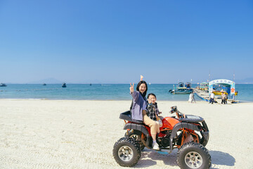 Asian kid and mom riding ATV at in Xunliao Bay, Huizhou city, Guangdong Province, China, during January