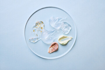 Assorted skincare gels and creams on clear petri dish. Multifunctional cosmetic concept