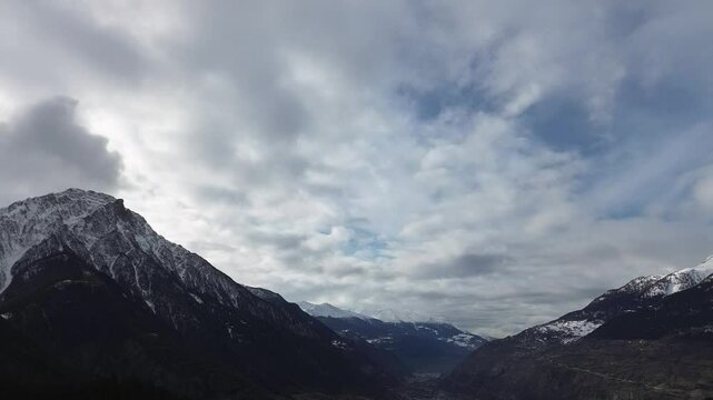 Majestic mountain landscape with snow-capped peaks under a dramatic cloudy sky. A breathtaking view of natures beauty, perfect for travel, adventure, and scenic footage. High quality FullHD footage