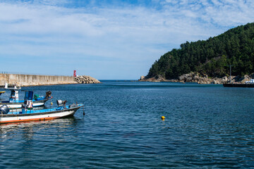 Fototapeta premium fishing boats and lighthouse at the harbor
