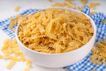 Raw Mafaldine pasta with ingredient for cooking