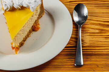 Delightful slice of creamy cake on a rustic wooden table in a cozy cafe