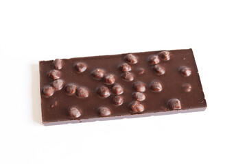 Dark chocolate with nuts, side view. Whole chocolate bar on white background. Food concept, sweets. Chocolate bar with whole hazelnuts
