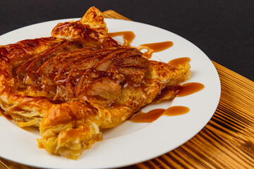 Flaky pastry dessert drizzled with caramel and adorned with apples