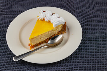 Delightful slice of creamy mango cheesecake with whipped cream topping