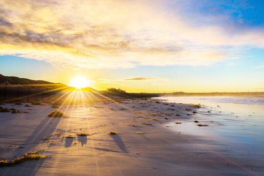 Sun shines over the land on a deserted beach.