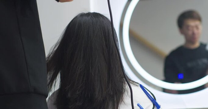 A Chinese woman getting her hair cut at a hair salon.