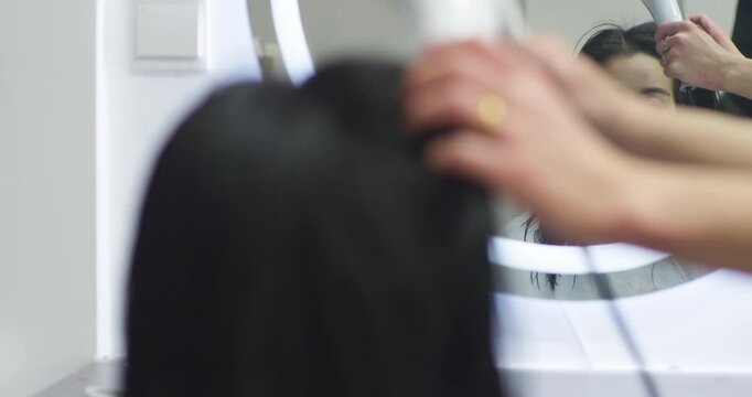 A Chinese woman getting her hair cut at a hair salon.