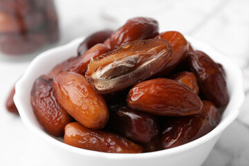 Tasty sweet dried dates in bowl on table, closeup