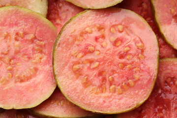 Many juicy slices of guava as background, above view