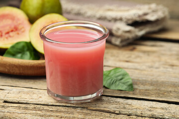 Refreshing guava juice and fresh fruits on wooden table, closeup