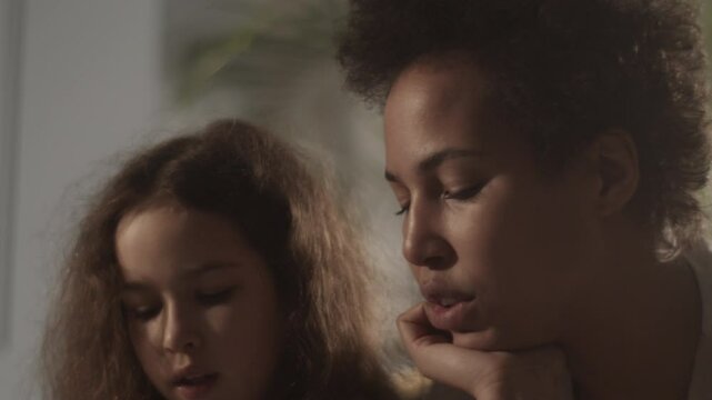 Young mother teaching daughter solfeggio music in room