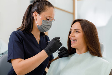Dentist examines patient in modern dental office during routine check-up