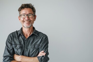 Portrait of a joyful man in his 40s with arms crossed while standing against white background