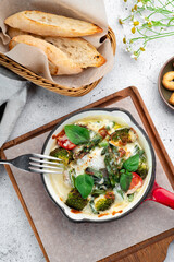 Baked broccoli, asparagus and tomatoes with mozzarella and parmesan cheese in a pan. Italian dish 