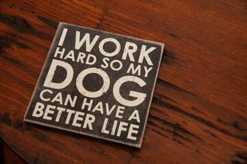A creative wooden coster with a sentimental phrase about dogs, displayed on a rustic wooden table,...