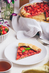 Slice Of Delicious Fresh Baked Vegan Strawberry Galette With Mint Leaves On White Ceramic Plate