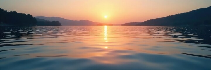 Fototapeta premium Shimmering water ripples on a calm lake surface at dawn, serene, lake scenery, calm