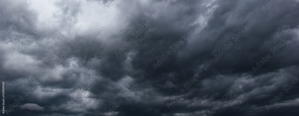 Poster a dramatic, stormy sky filled with dark, dense clouds forebodes an approaching windstorm, capturing 
