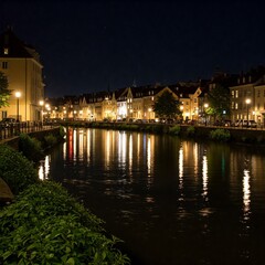 Obraz premium A picturesque European town at night with historic buildings reflecting in a calm river, illuminated by warm streetlights along the waterfront. 