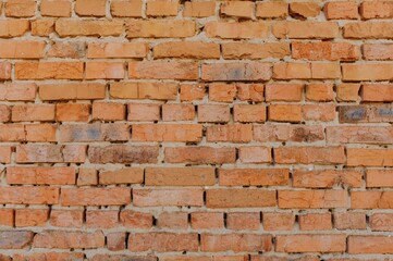 A close-up of a textured brick wall showcasing warm orange and brown tones with different patterns, perfect for backgrounds or design inspiration.