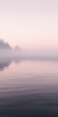 Fototapeta premium Misty river water reflects soft morning light at dawn