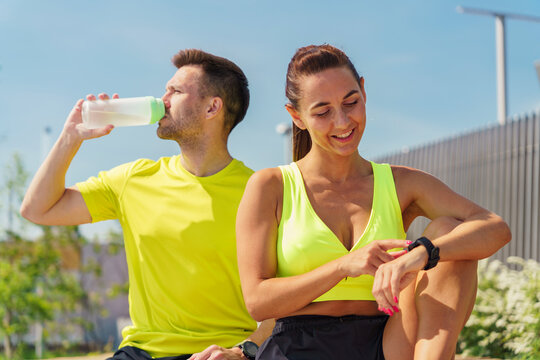 Active fitness enthusiasts enjoying a sunny day in an urban park while tracking their workouts