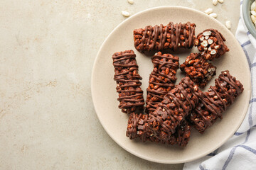 Delicious chocolate puffed rice bars on gray textured table, top view. Space for text