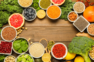 Superfood. Frame of different healthy food products on wooden table, flat lay. Space for text