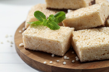 Delicious puffed rice bars and mint on white wooden table, closeup