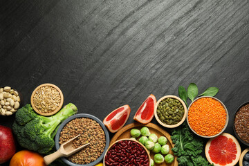 Different superfood products on black table, flat lay. Space for text