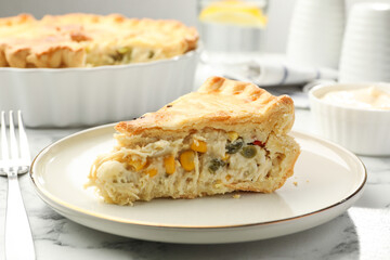 Piece of tasty homemade pie with chicken and vegetables on white marble table, closeup