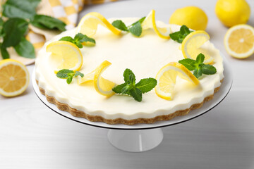 Delicious lemon cheesecake with mint and fresh fruits on white wooden table, closeup
