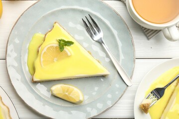 Piece of delicious cheesecake with lemon curd served on white wooden table, top view
