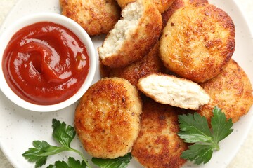 Tasty patties, parsley and ketchup on white table, top view