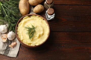 Delicious mashed potato with dill served on wooden table, flat lay. Space for text