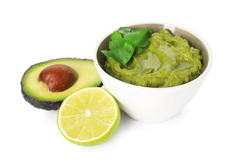 Tasty avocado dip in bowl, lime and parsley isolated on white
