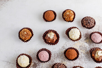 Homemade chocolate truffles with dark chocolate ganache covered with pink powder, waffle crumbles, gold flakes, coconut and nuts