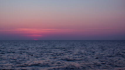 Obraz premium ピンク色の夕焼けと水平線と海