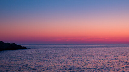 Fototapeta premium ピンク色の夕焼けと水平線と海
