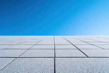 A bright blue sky above a tiled concrete surface