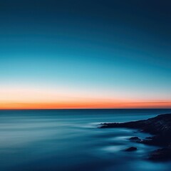 Naklejka premium A serene seascape at sunset, featuring calm waters and a gradient sky transitioning from blue to warm orange hues.