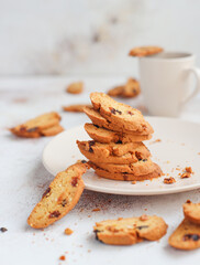 Italian raisin almond biscotti and glass of milk on light background.