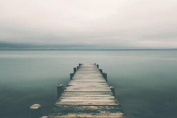 Fototapeta premium Selective focus wooden pier into the sea with foggy view, Dock for fisherman and small boat.