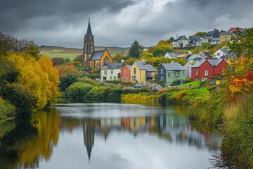 Obraz premium Charming Catholic Church Amidst Colorful Buildings in Donegal, Ireland's Autumn Landscape