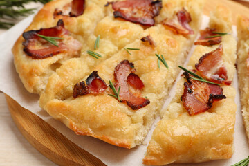 Slices of delicious focaccia bread with bacon and rosemary on table, closeup