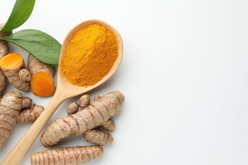 Turmeric powder in spoon, roots and leaves on white background, flat lay. Space for text